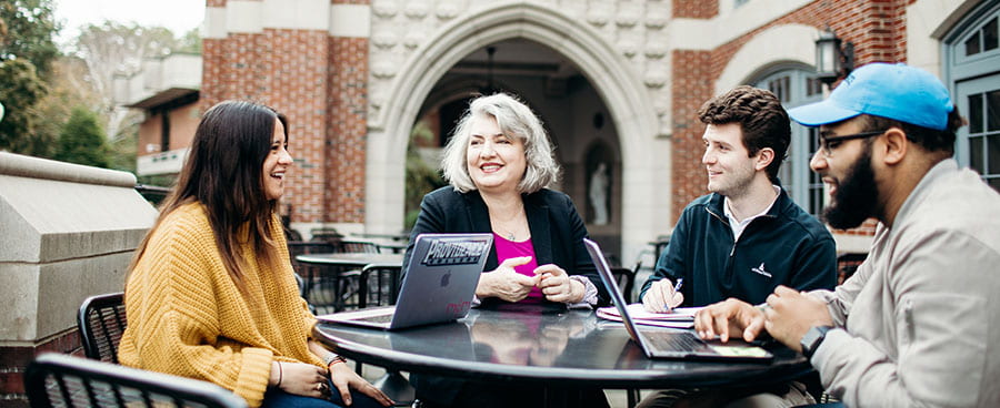 Faculty and students outside Ruane building